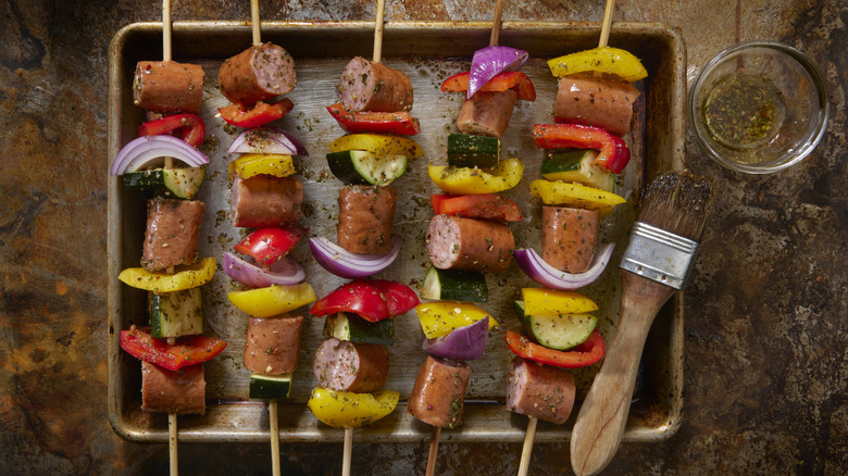 Grilled vegetables and hot dogs on skewers