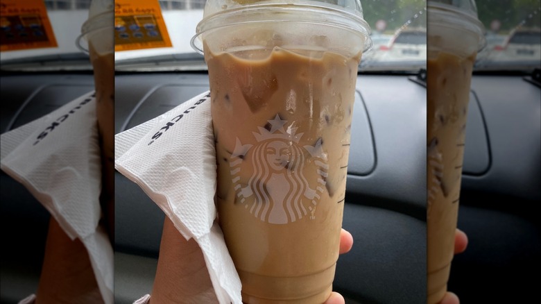 A hand holds a venti iced Butterscotch Latte from Starbucks