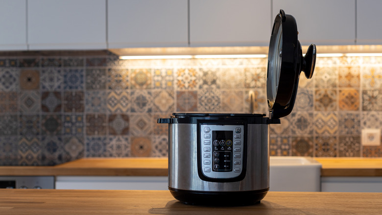 A black and silver Instant Pot shown open on a countertop