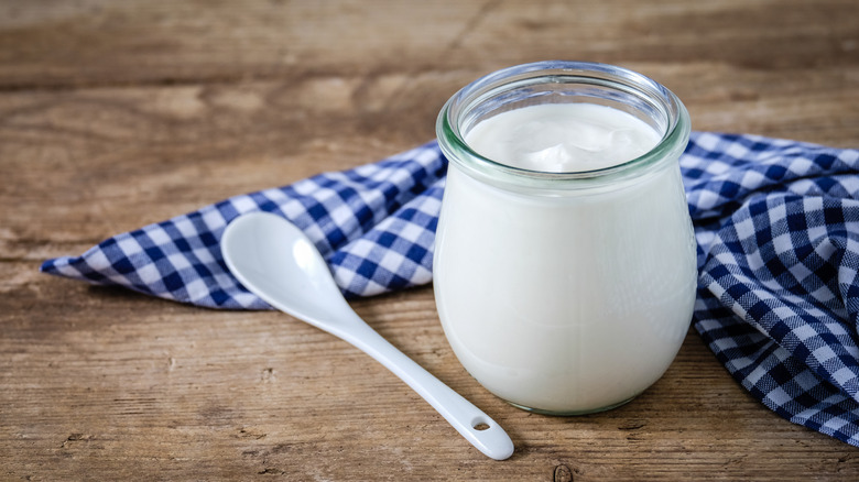 Jar of yogurt with spoon and napkin