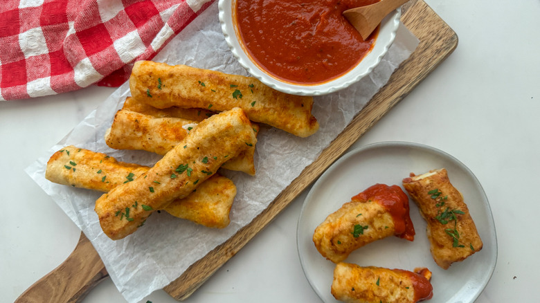 pizza mozzarella sticks on wooden board and plate