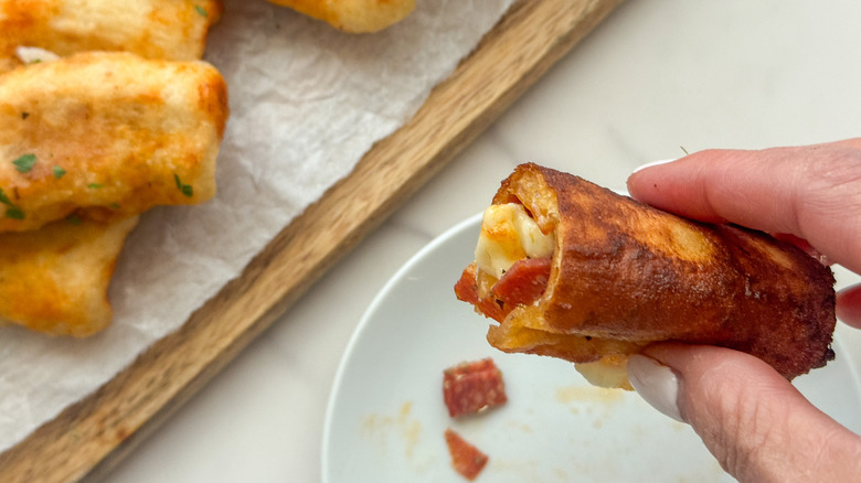 hand holding pizza mozzarella stick