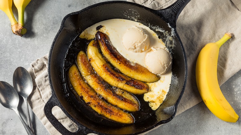 Bananas Foster dessert in a cast iron skillet with ice cream