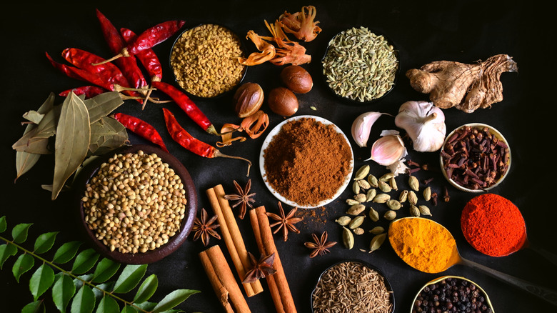 Assorted dried spices and foods against black background