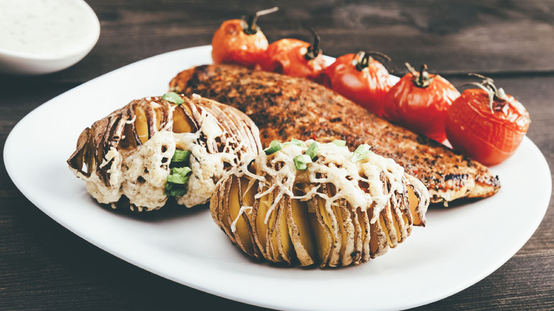 Cheesy Hasselback potatoes with roasted salmon and tomatoes