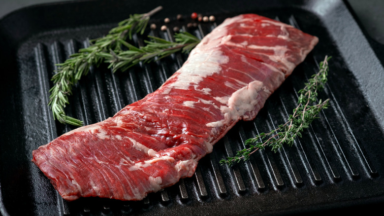 raw skirt steak with sprigs of rosemary
