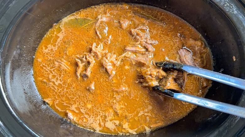Shredded beef chuck and barbacoa sauce in slow cooker