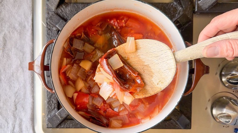 Barbacoa sauce ingredients simmering in saucepan with wooden spoon