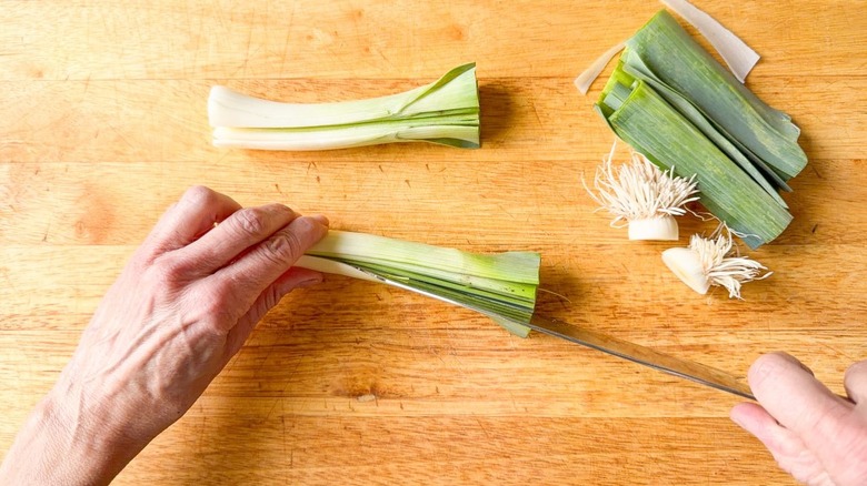 Trimming and slicing leeks on cutting board