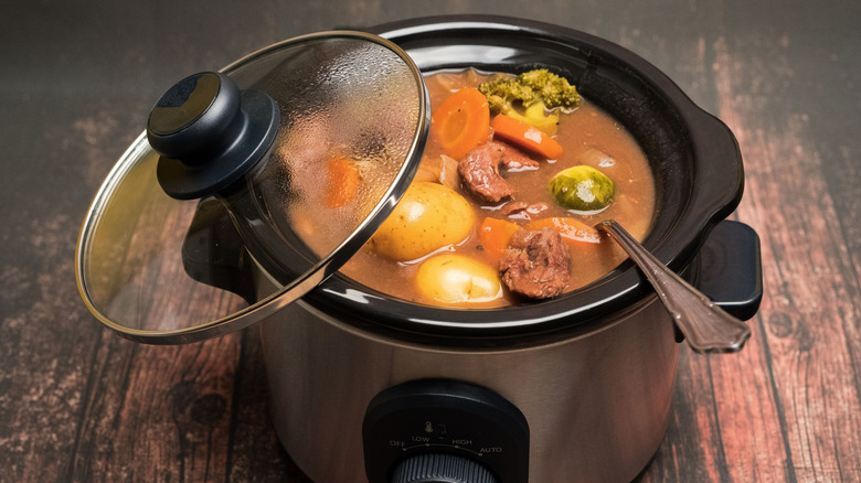 beef and vegetable stew in a slow cooker with a spoon