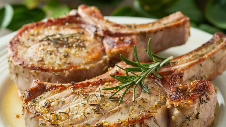seared pork chops with sauce and herbs