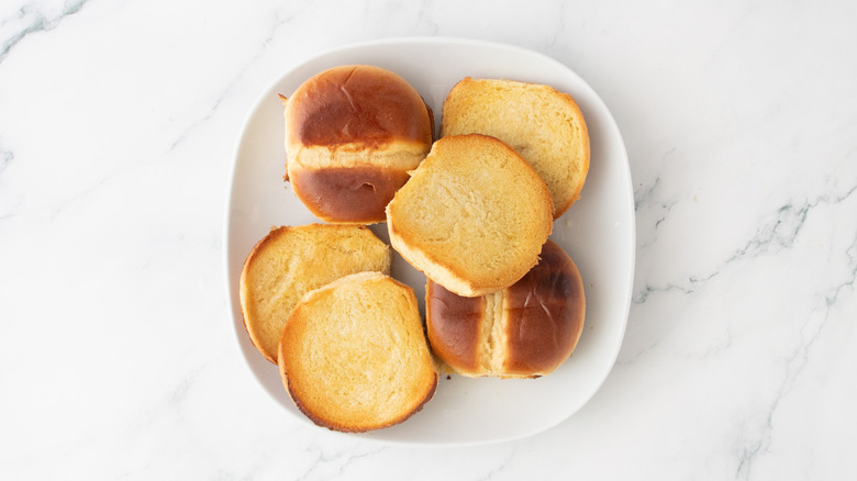 Butter-toasted brioche rolls on a white plate