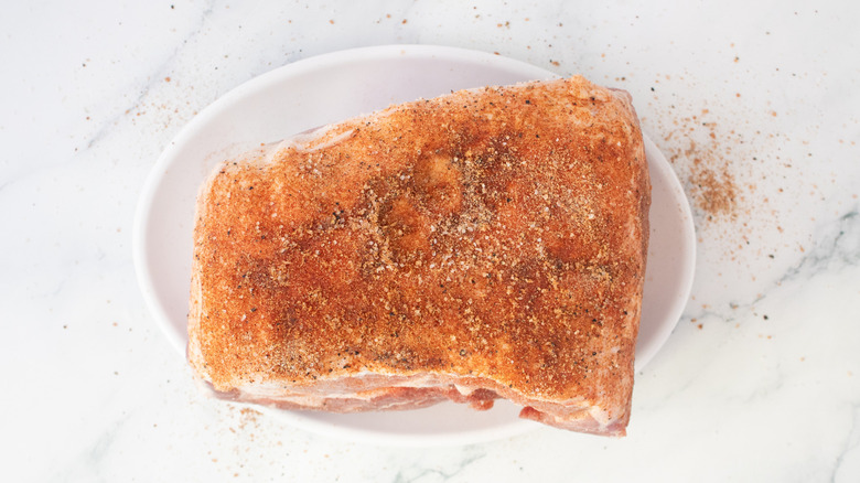 Raw pork butt rubbed with oil and seasoning