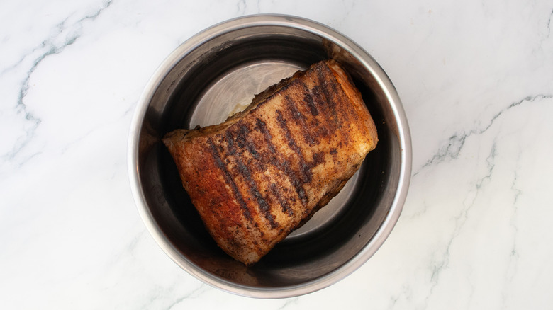 Grilled pork butt in a large slow cooker pot