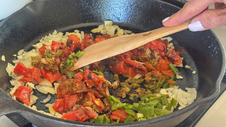 hand stirring items in pan