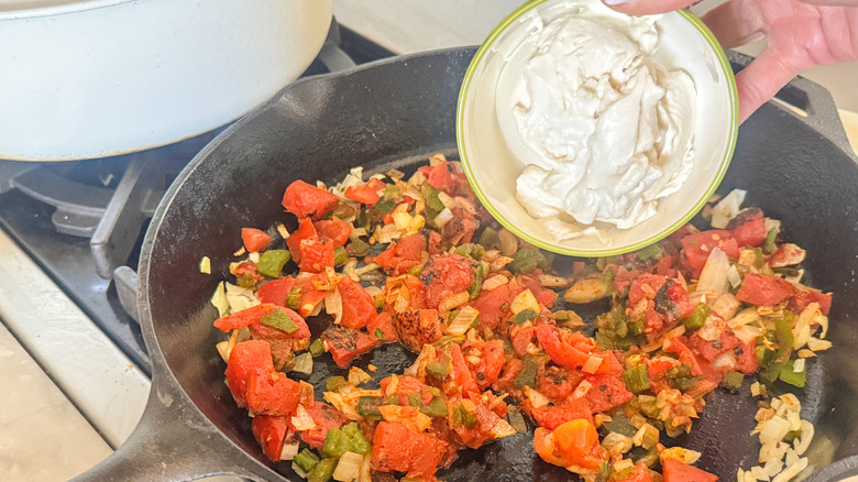 hand adding cream cheese