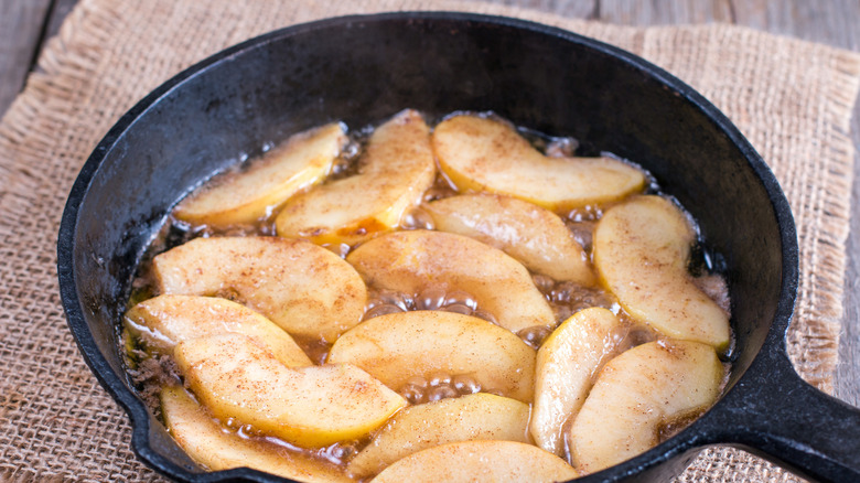 Apple slices are cooking in a skillet
