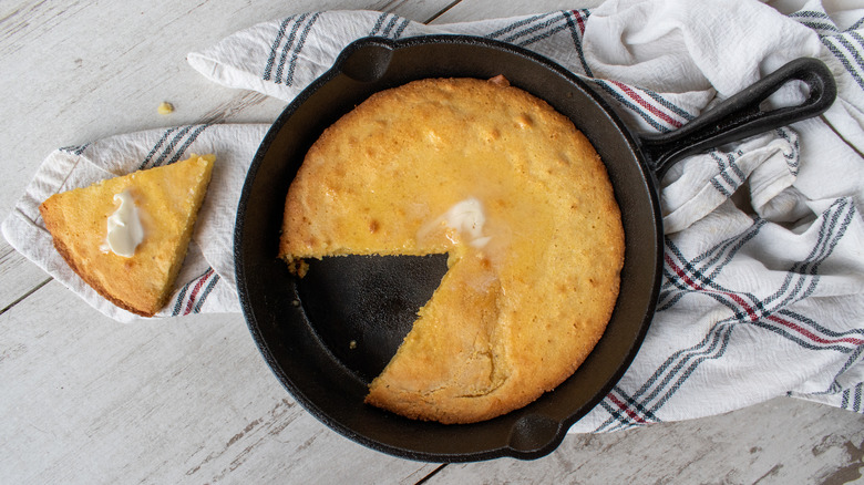 Cornbread in a cast iron pan is photographed from above.
