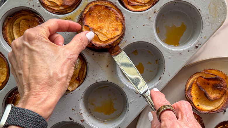 hands lifting stacks out of tin