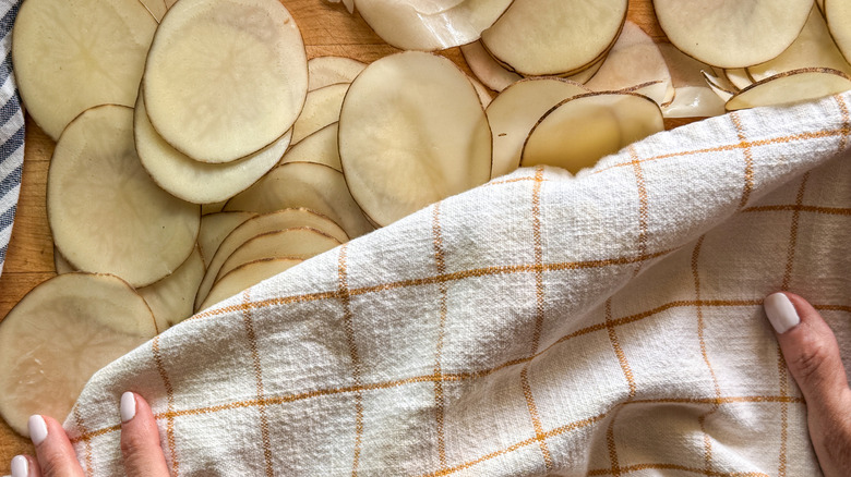 hands drying slices with towel