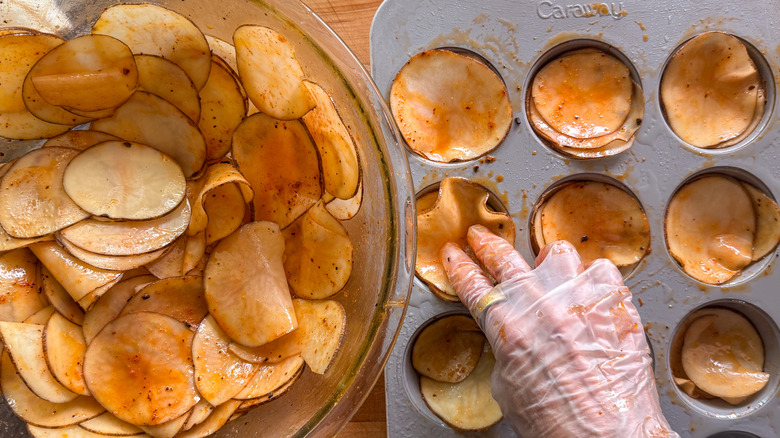 hand adding slices to tin