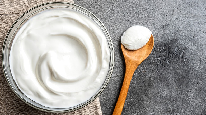 Clear bowl of sour cream over a cloth, taupe-colored napkin