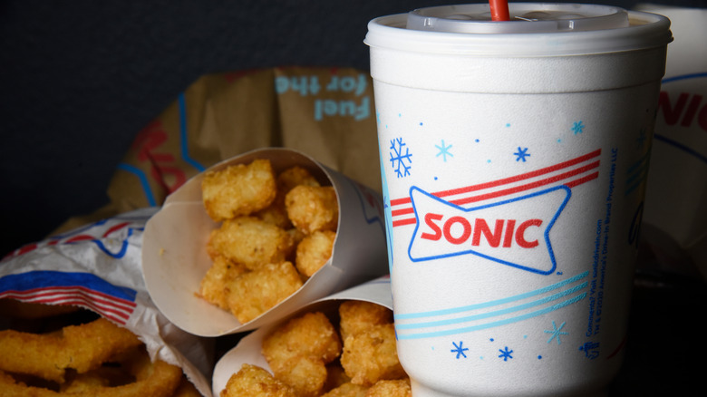 Sonic-branded cup next to tater tots and onion rings