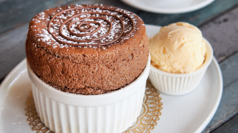 A chocolate soufflé with a scoop of ice cream next to it.