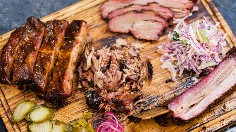 A Southern bbq spread with brisket and sides on a wooden board