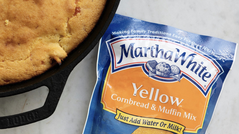 a bag of martha white corn meal mix next to a pan of cornbread