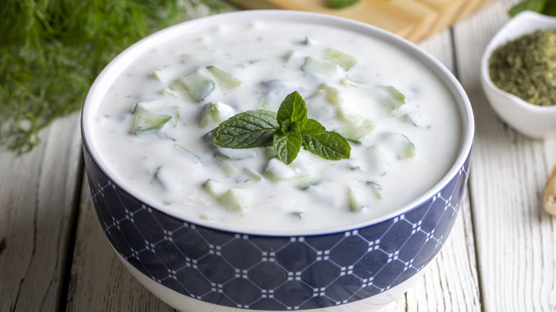 A bowl of tzatziki on a wooden table.