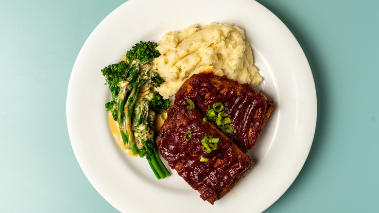 Plate of meatloaf with mashed potatoes and broccolini