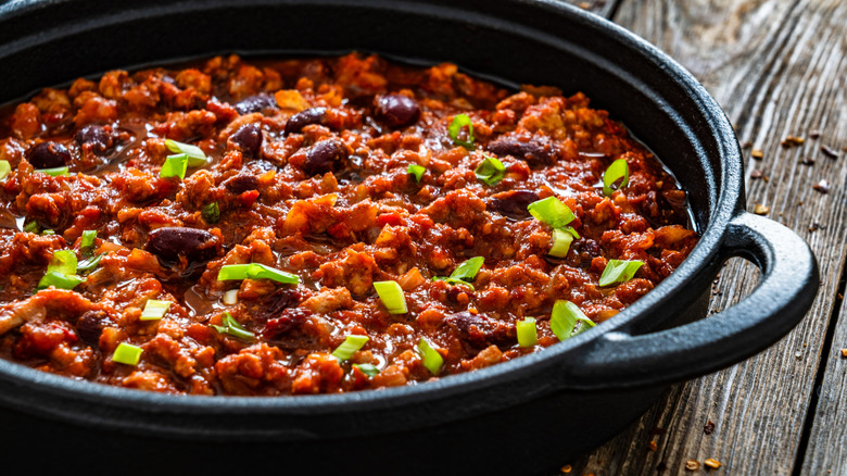 Chili with green onions in a cast iron skillet