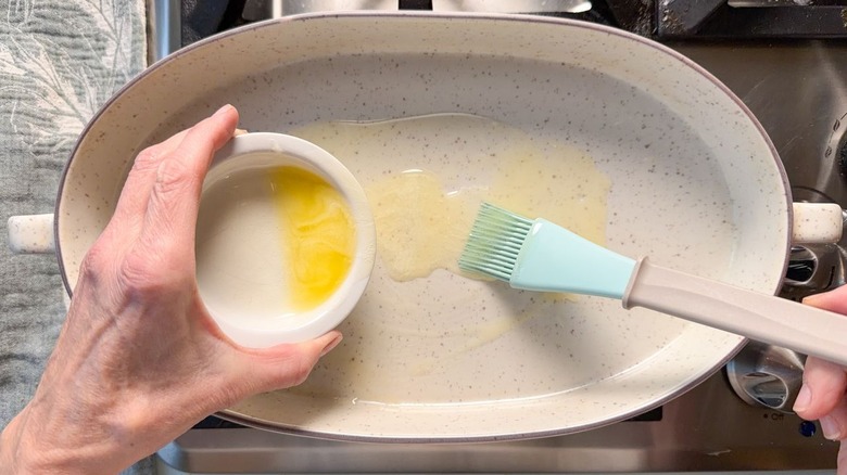 Brushing melted butter on a casserole dish