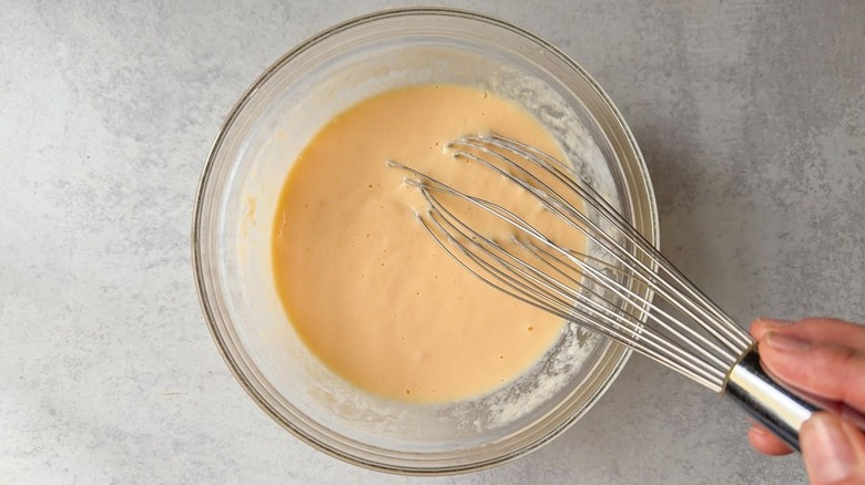 Whisking together eggs and buttermilk in glass bowl