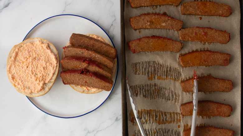 Pimento cheese-dressed sandwich topped with meatloaf and meatloaf on a baking sheet