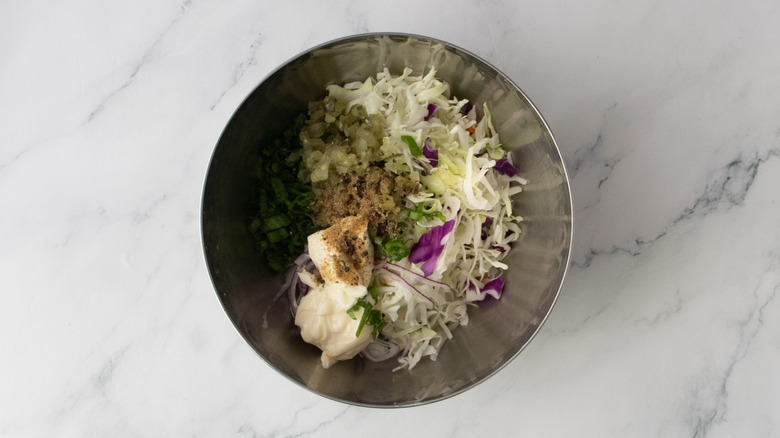 Pickle and cabbage cole slaw ingredients in a medium bowl