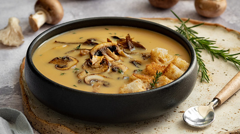 mushroom soup served with croutons, rosemary, soup in a bowl