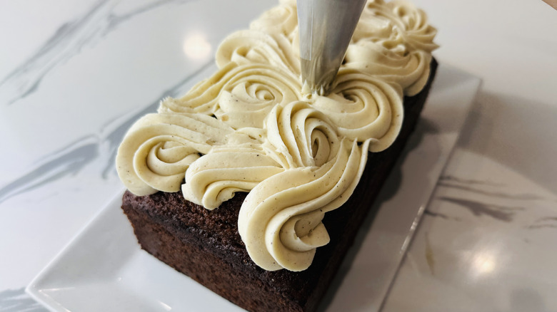 Piping frosting onto gingerbread loaf