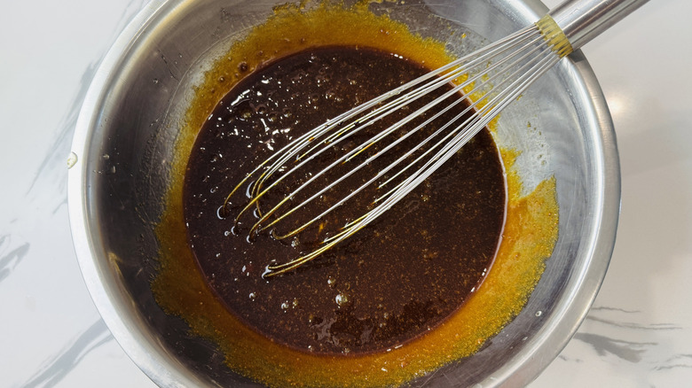 Wet cake batter ingredients in bowl with whisk