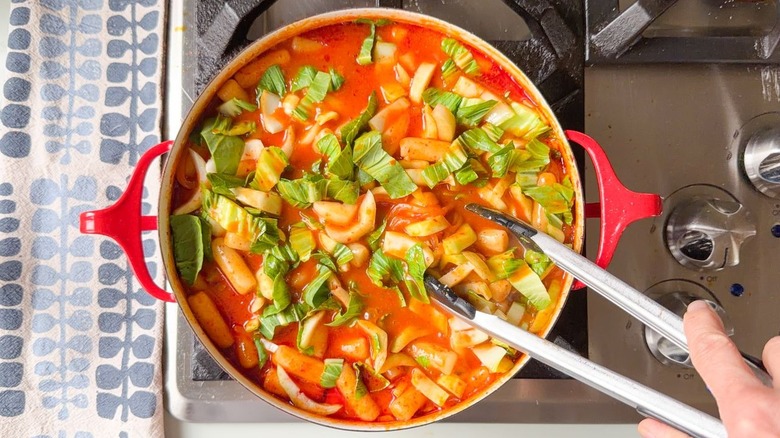 Stirring bok choy into tteokbokki
