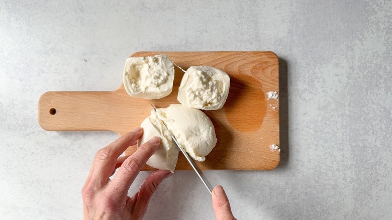 Slicing burrata on cutting board