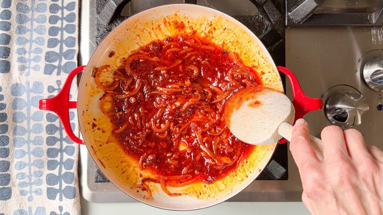 Cooking the sauce for tteokbokki in a red pan on stovetop