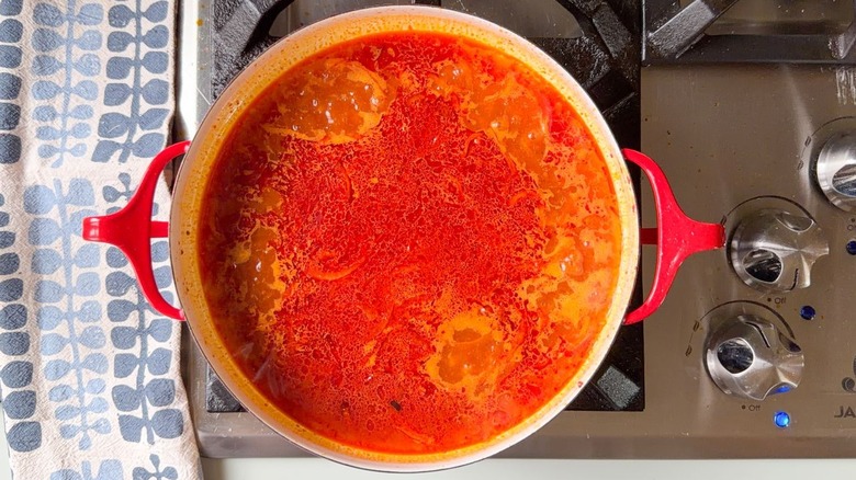 Tteokbokki sauce simmering in red pan on stovetop