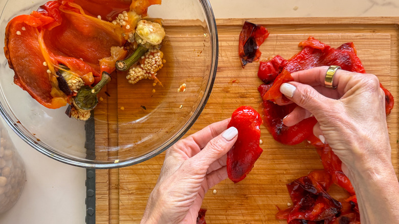 hands peeling peppers