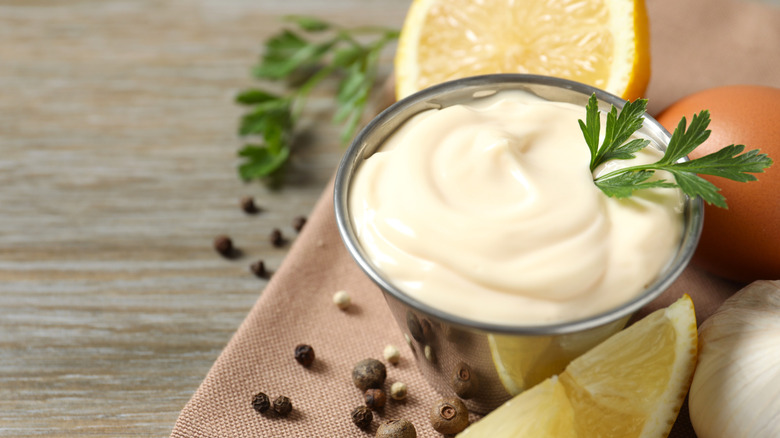 A metal ramekin of  mayonnaise.