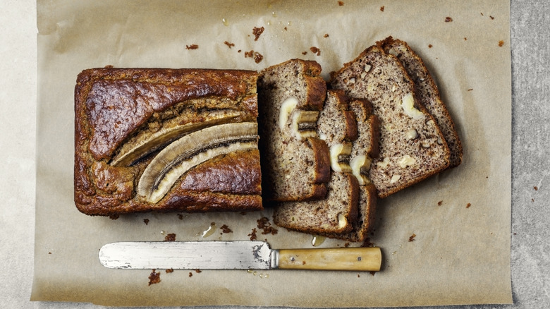 A banana load, with several slices cut, set on a parchment paper