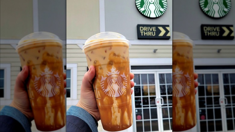 Hand holding sweet cream cold brew with caramel drizzle