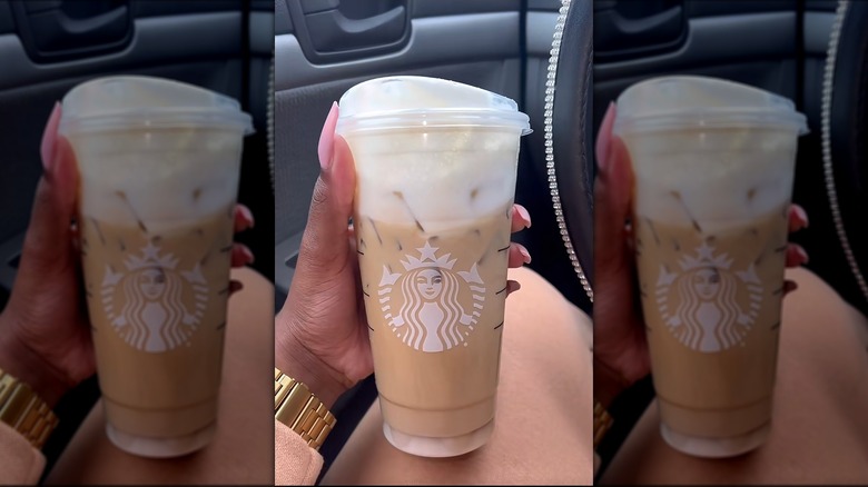 Hnad holding vanilla sweet cream cold brew with white chocolate mocha