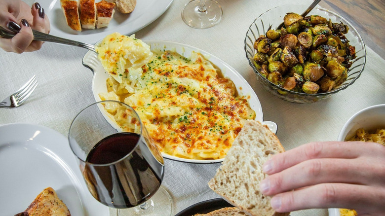 A person taking a spoonful of jalapeño au gratin potatoes at Ocean Prime